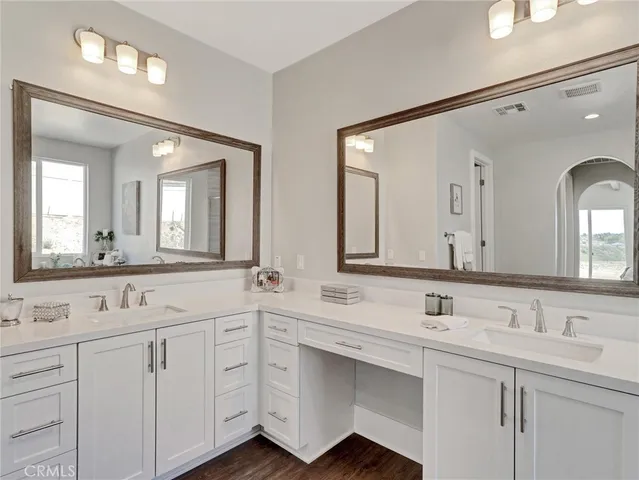 a hallway with white cabinets and wooden floor