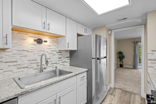 a kitchen with a refrigerator sink and cabinets
