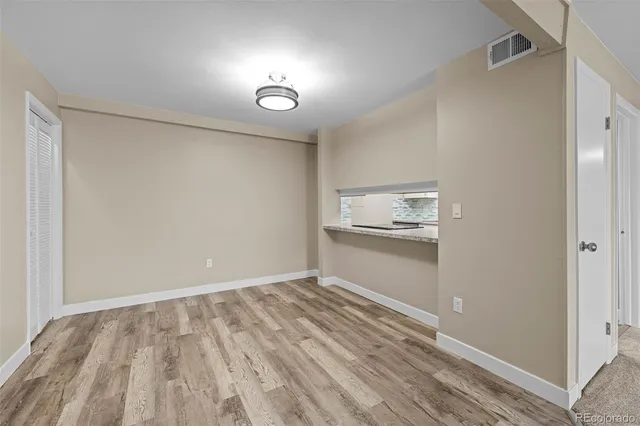 a view of empty room with wooden floor