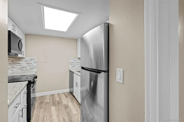 a view of kitchen with a refrigerator cabinets and a window