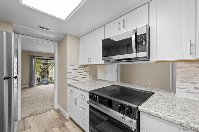 a kitchen with stainless steel appliances granite countertop a stove and a microwave