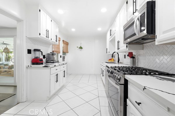 4866 Sunnyside Drive Riverside, CA 92506 - Photo 12 of 29 a kitchen with stainless steel appliances granite countertop a sink stove and cabinets
