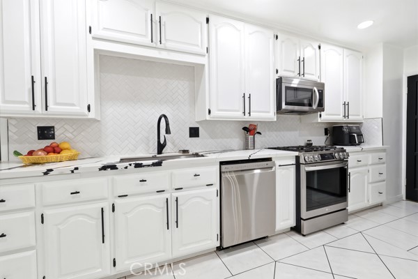 4866 Sunnyside Drive Riverside, CA 92506 - Photo 13 of 29 a kitchen with white cabinets sink and white appliances