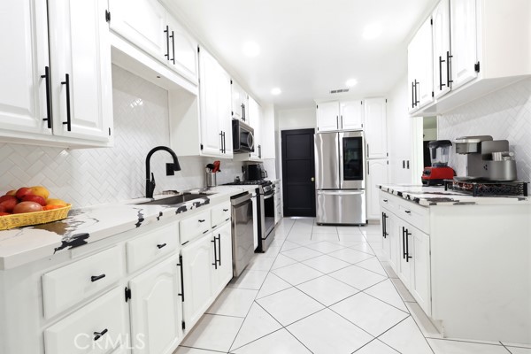 4866 Sunnyside Drive Riverside, CA 92506 - Photo 14 of 29 a kitchen with stainless steel appliances a refrigerator sink and cabinets