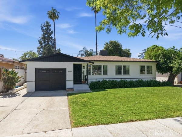 4866 Sunnyside Drive Riverside, CA 92506 - Photo 2 of 29 a front view of a house with a yard and garage