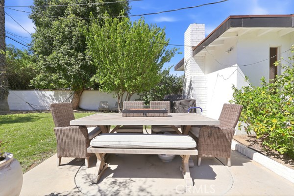4866 Sunnyside Drive Riverside, CA 92506 - Photo 26 of 29 a view of a patio with table and chairs potted plants and a palm tree