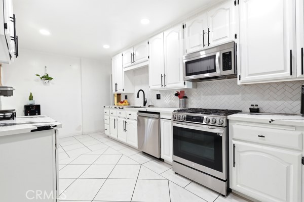 4866 Sunnyside Drive Riverside, CA 92506 - Photo 10 of 29 a kitchen with white cabinets stainless steel appliances and sink