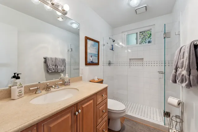 a bathroom with a granite countertop sink toilet and shower