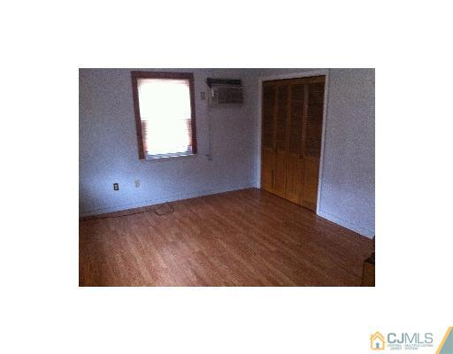 59 Middle Hill Road Colonia, NJ 07067 - Photo 3 of 25 a view of an empty room with wooden floor and a window