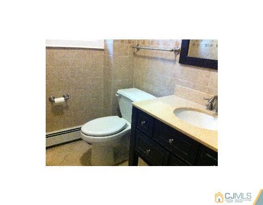 59 Middle Hill Road Colonia, NJ 07067 - Photo 22 of 25 a bathroom with a sink a toilet and a mirror