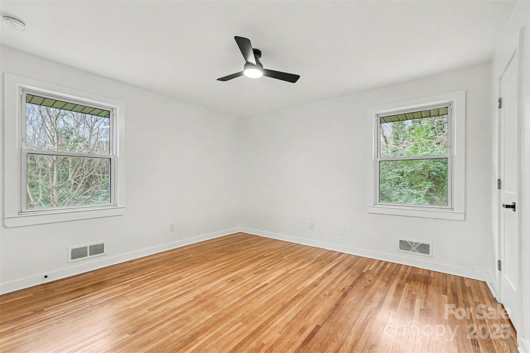 3417 Sudbury Road Charlotte, NC 28205 - Photo 6 of 18 a view of empty room with wooden floor and fan