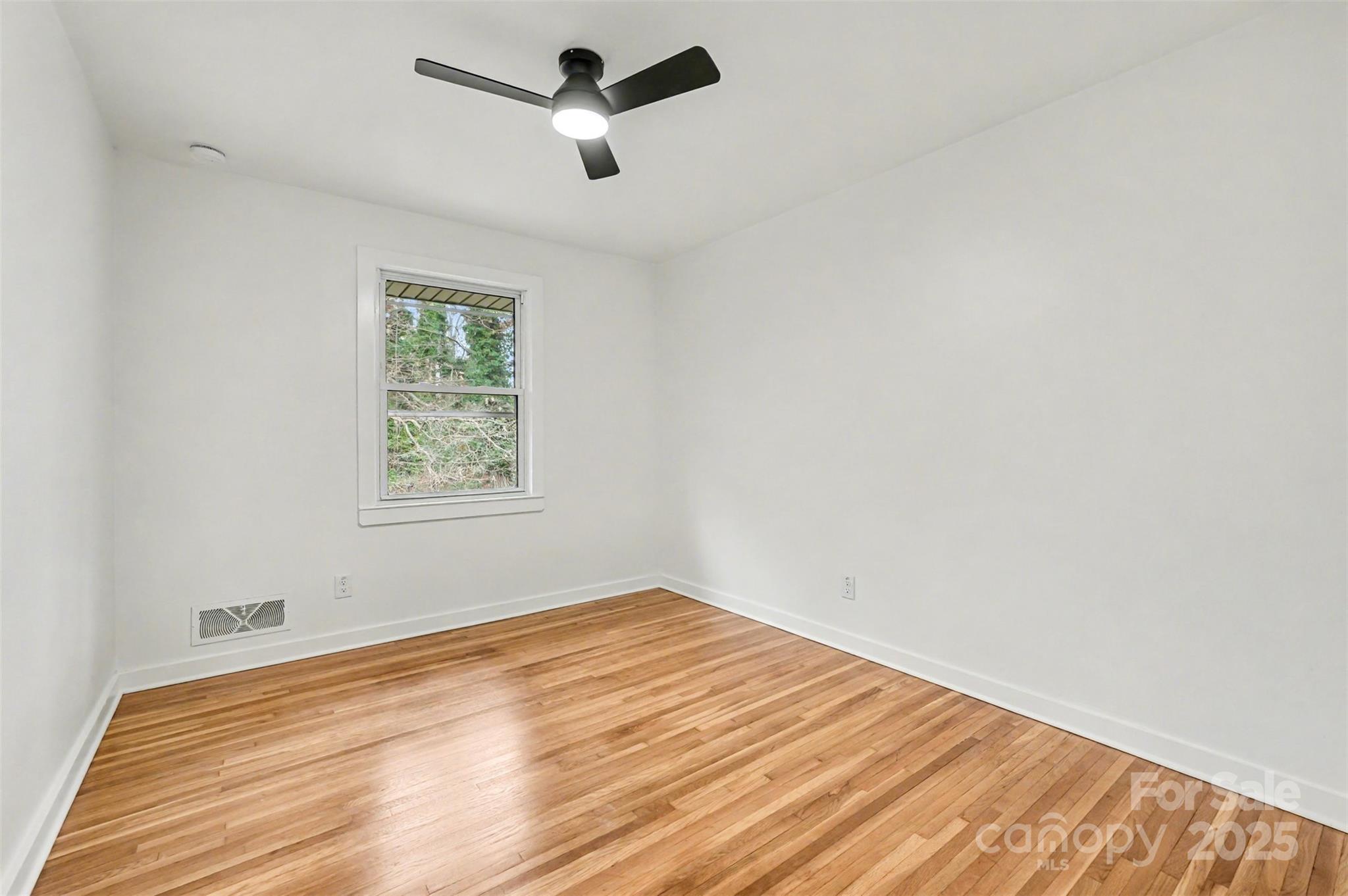 3417 Sudbury Road Charlotte, NC 28205 - Photo 9 of 18 an empty room with a window and ceiling fan