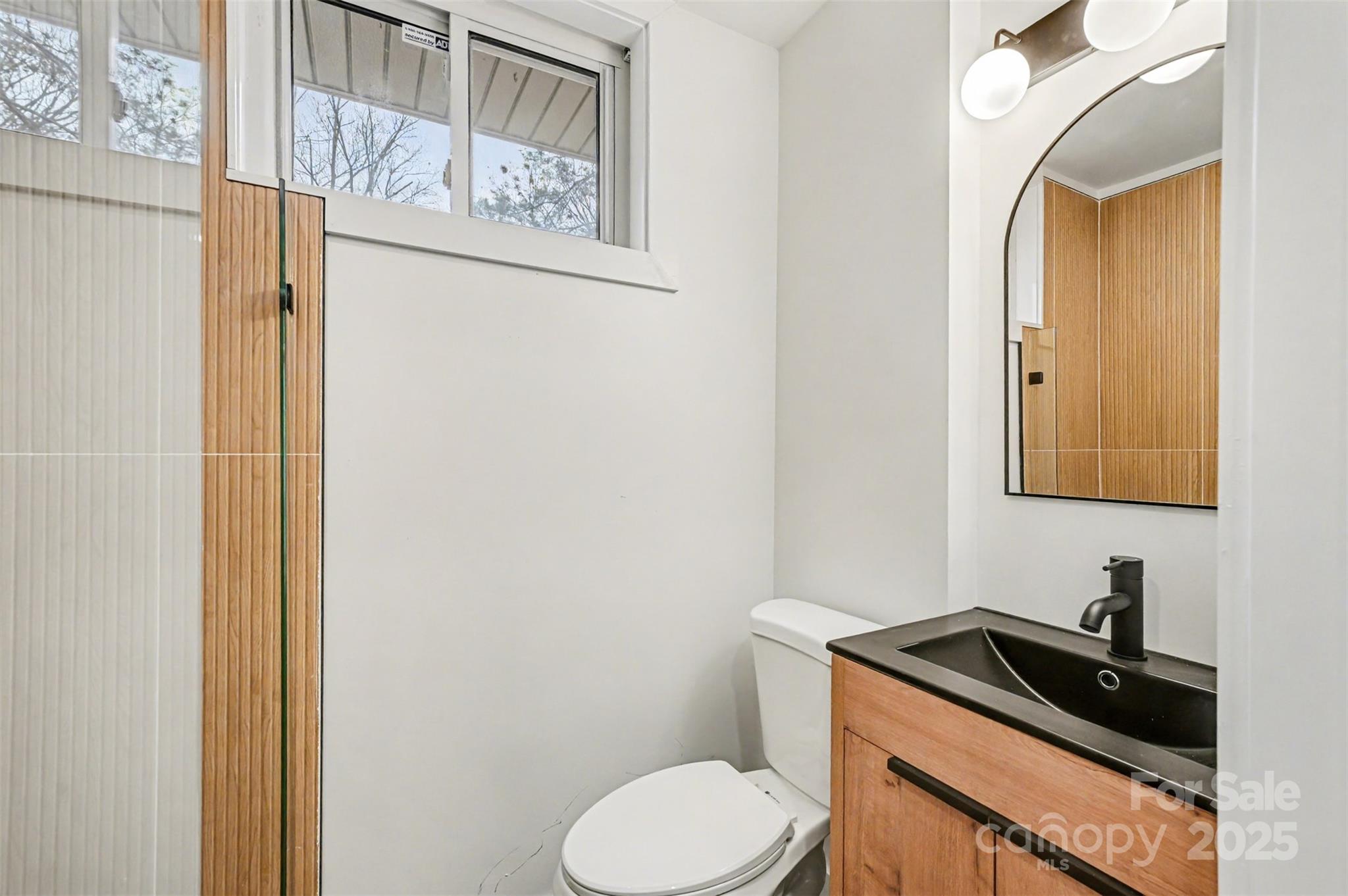 3417 Sudbury Road Charlotte, NC 28205 - Photo 10 of 18 a bathroom with a toilet sink and mirror