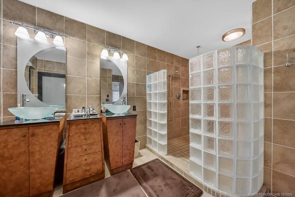 5609 Southeast Lamay Drive Stuart, FL 34997 - Photo 40 of 40 a bathroom with a double vanity sink and a mirror