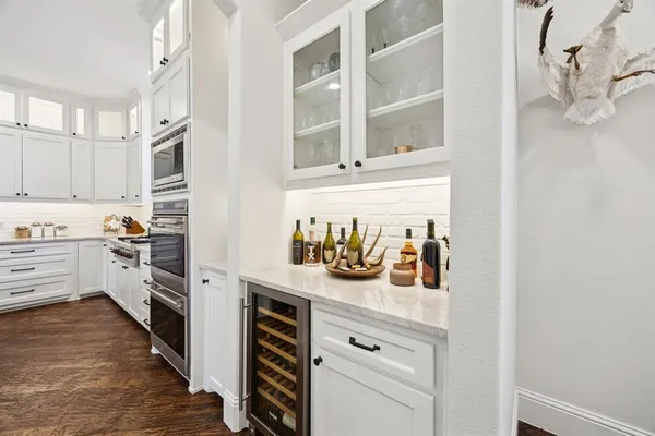 a kitchen with a refrigerator and white cabinets