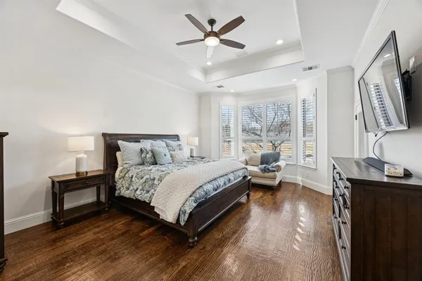 a spacious bedroom with a bed and a flat screen tv