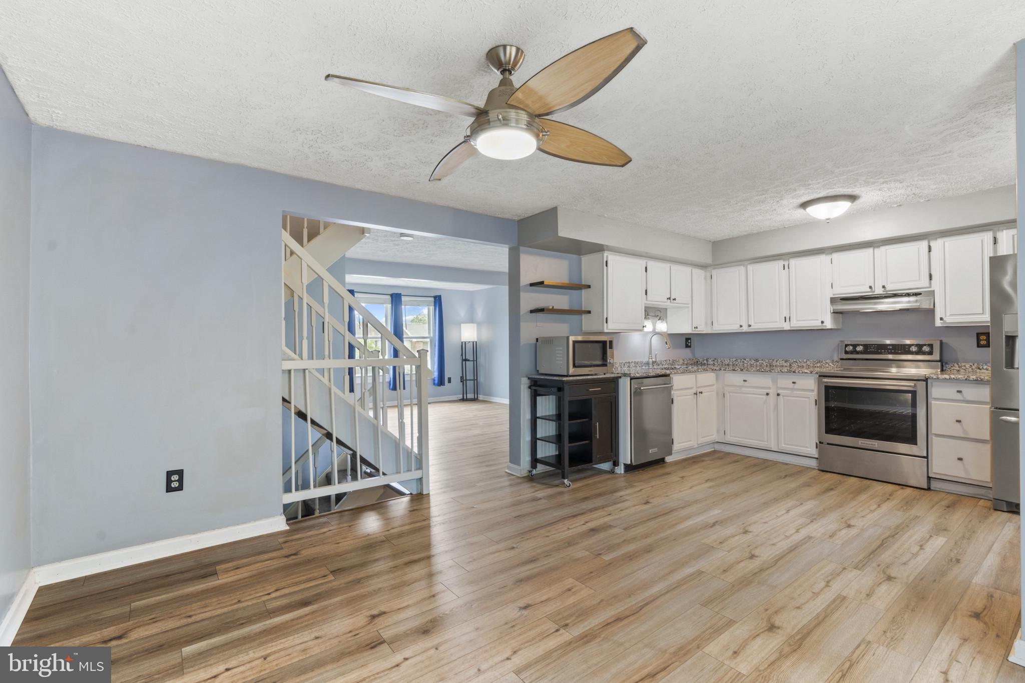 3210 Split Oak Court Abingdon, MD 21009 - Photo 6 of 17 a kitchen with granite countertop a stove cabinets and wooden floor