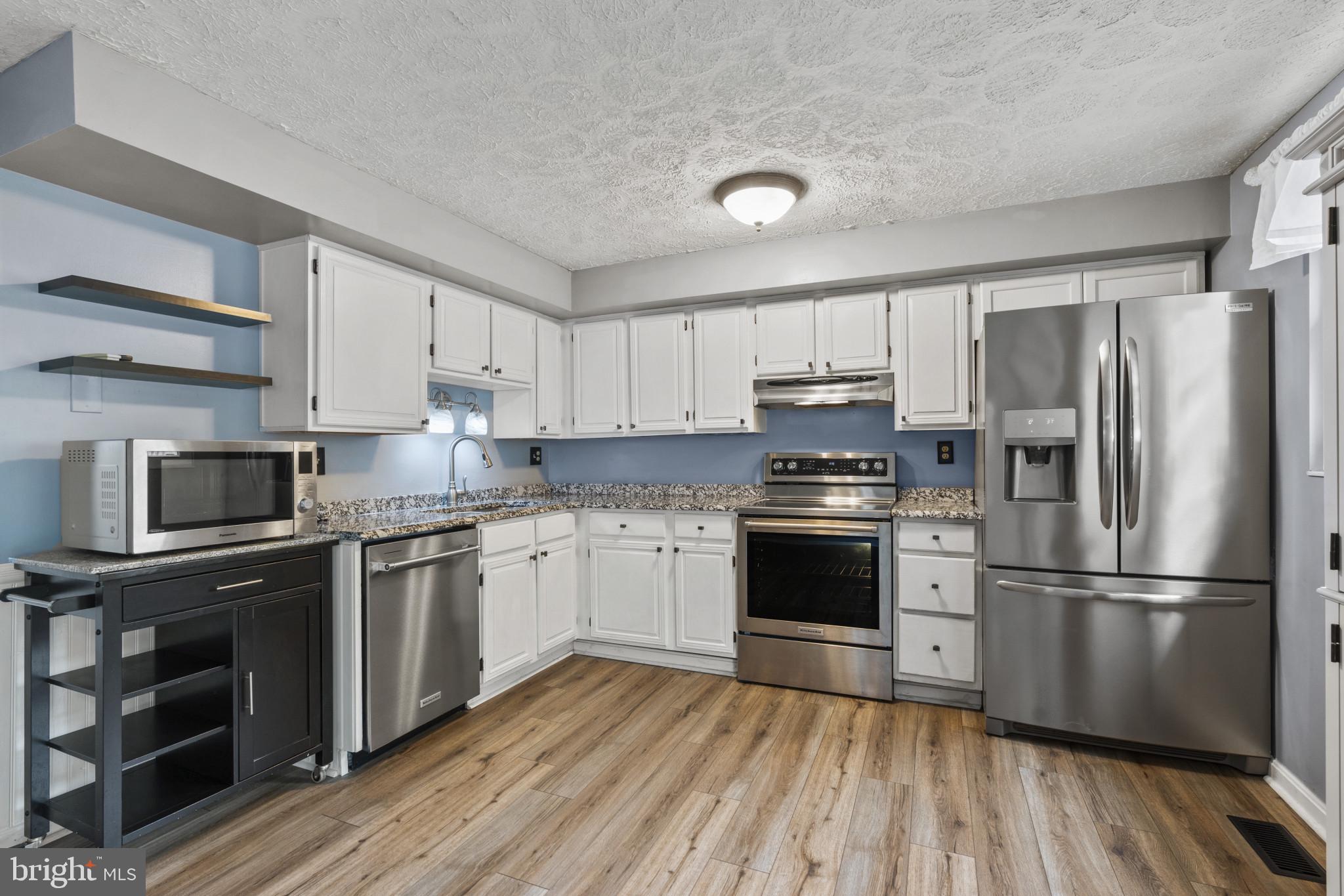 3210 Split Oak Court Abingdon, MD 21009 - Photo 7 of 17 a kitchen with granite countertop stainless steel appliances and wooden floor