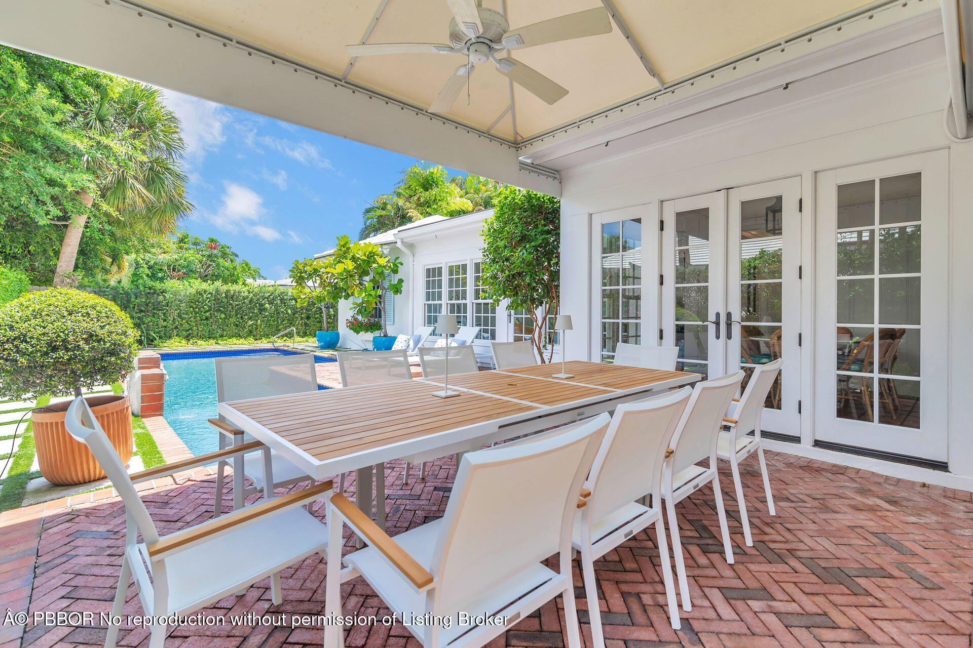 255 Colonial Lane Palm Beach, FL 33480 - Photo 22 of 32 a view of a patio with table and chairs with wooden floor and fence
