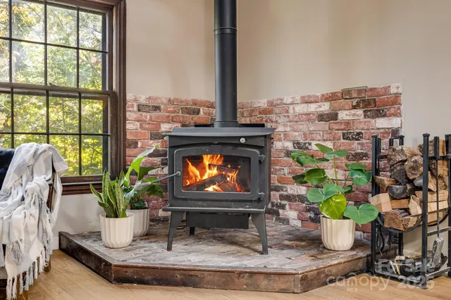 a living room with fireplace furniture and a potted plant