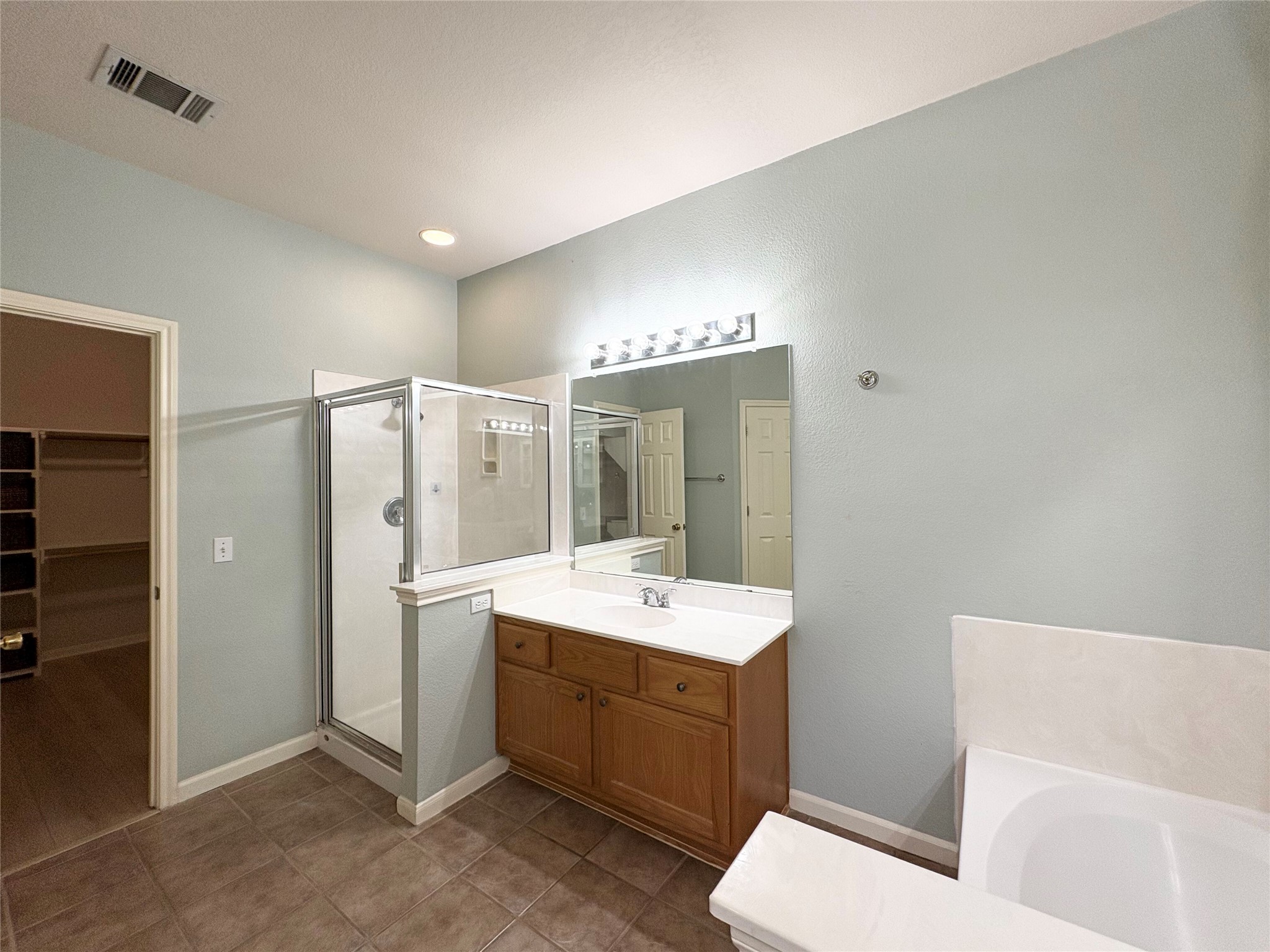 7006 Rambollet Terrace Round Rock, TX 78681 - Photo 20 of 38 A well-appointed primary bathroom features a glass-enclosed shower and a spacious vanity with an ample mirror.