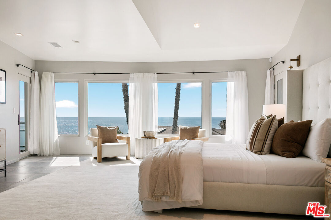 31558 Victoria Point Road Malibu, CA 90265 - Photo 32 of 55 a bedroom with a large bed and large windows