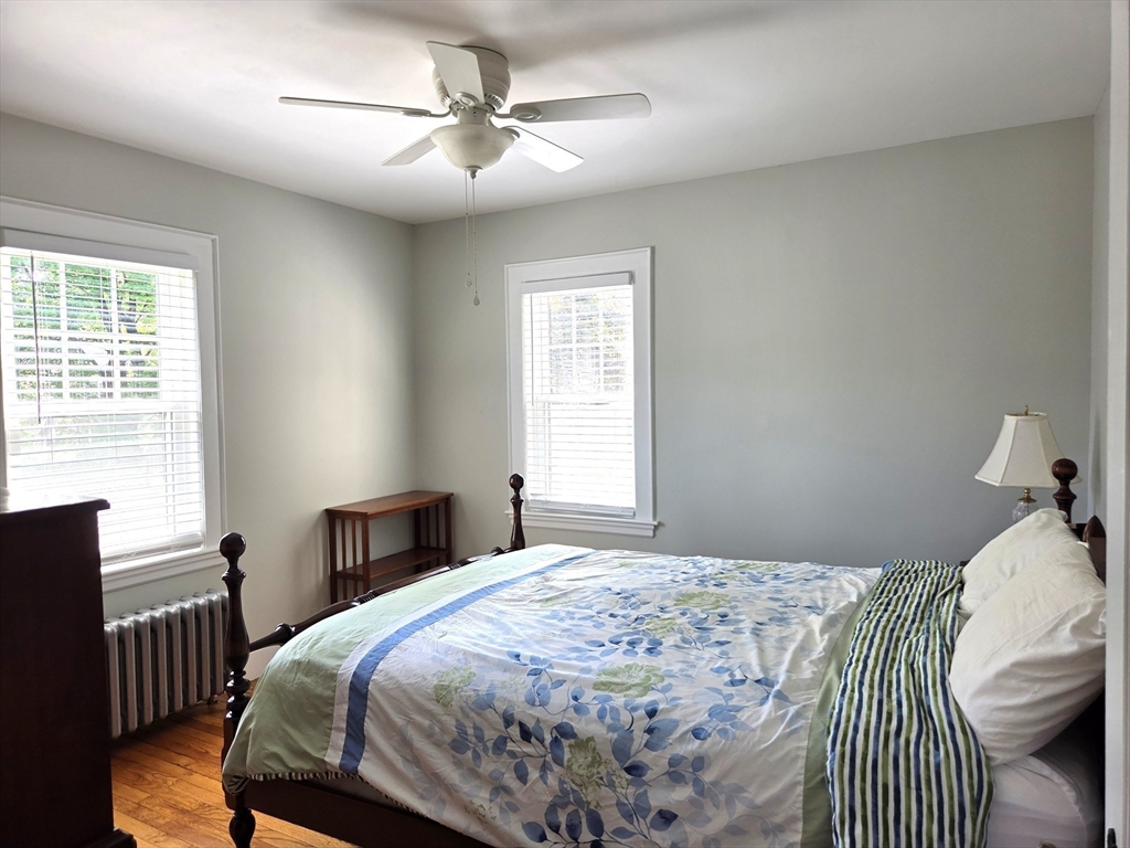 25 Waldeck Road Milton, MA 02186 - Photo 23 of 34 a bedroom with a bed and a chandelier