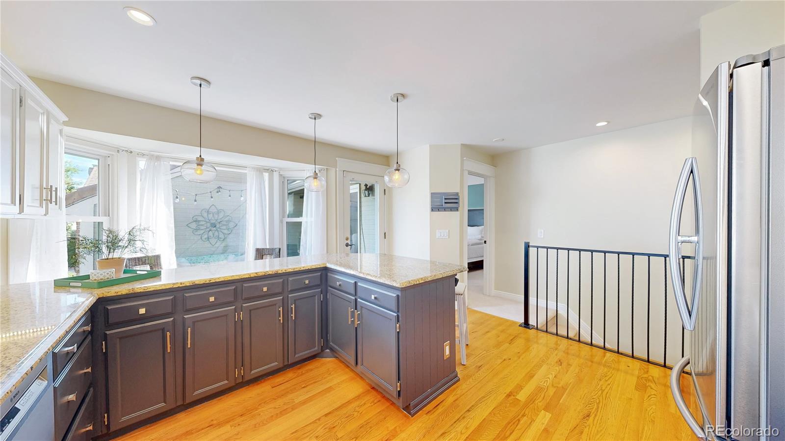 2335 Ranch Drive Westminster, CO 80234 - Photo 12 of 47 a large kitchen with kitchen island a large window a sink stainless steel appliances and cabinets