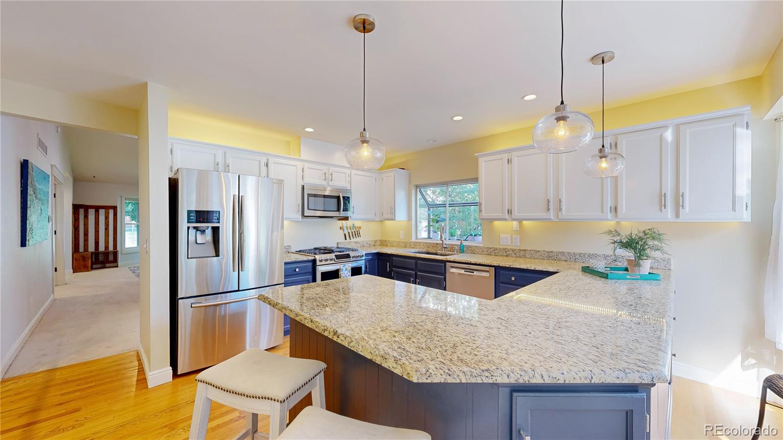 2335 Ranch Drive Westminster, CO 80234 - Photo 13 of 47 a kitchen with kitchen island a center island a sink stainless steel appliances and cabinets