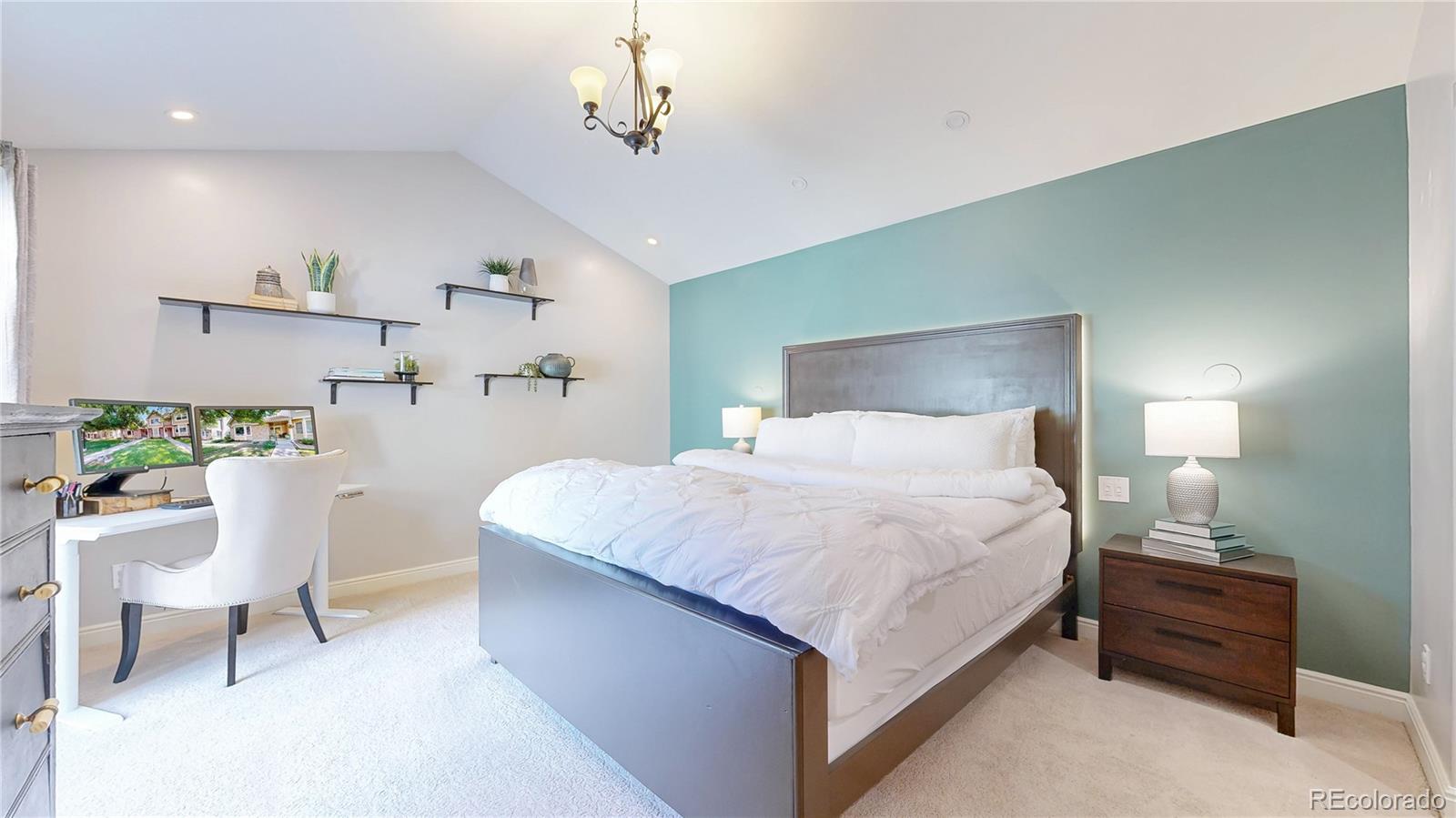 2335 Ranch Drive Westminster, CO 80234 - Photo 14 of 47 a bedroom with a large bed and a chandelier