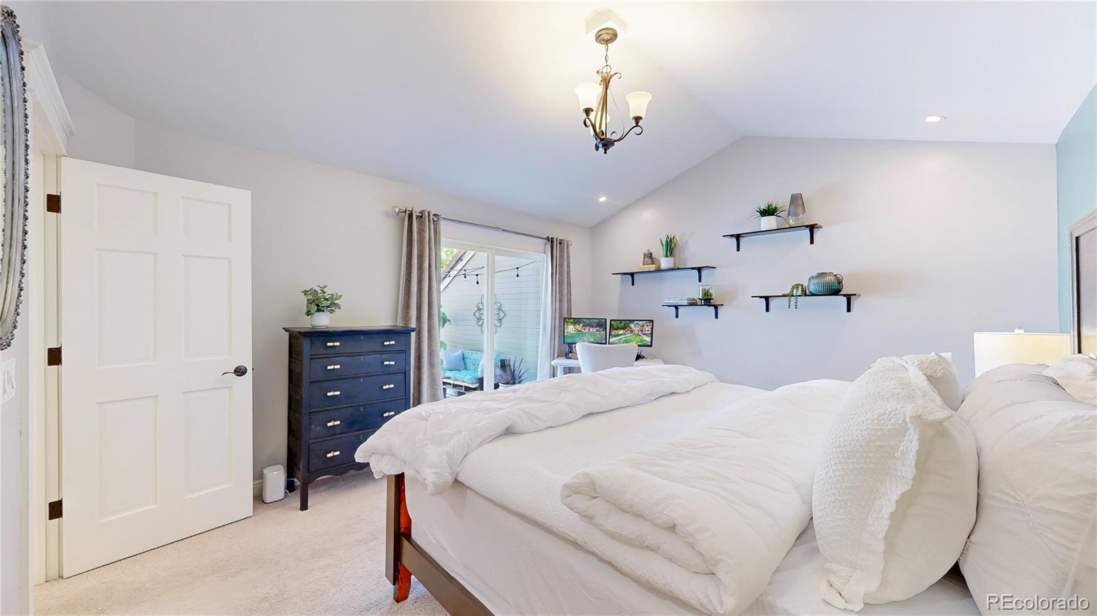 2335 Ranch Drive Westminster, CO 80234 - Photo 16 of 47 a bedroom with a bed and a chandelier