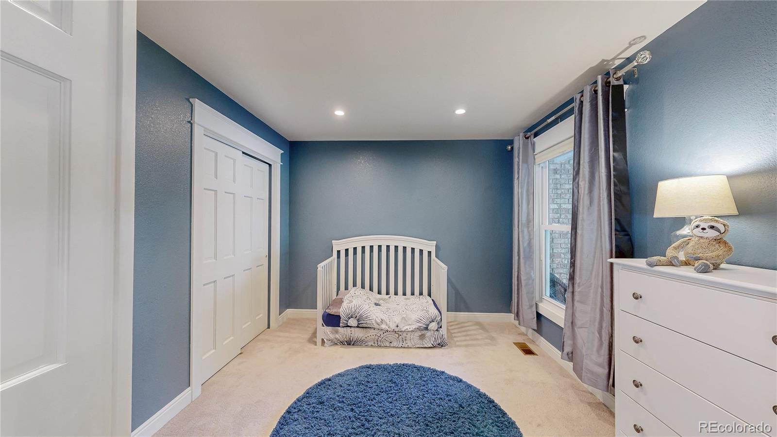 2335 Ranch Drive Westminster, CO 80234 - Photo 20 of 47 a bedroom with a bed and a lamp