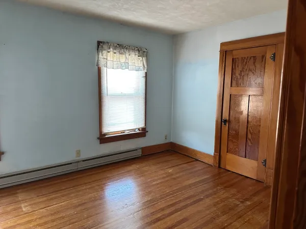 an empty room with wooden floor and closet
