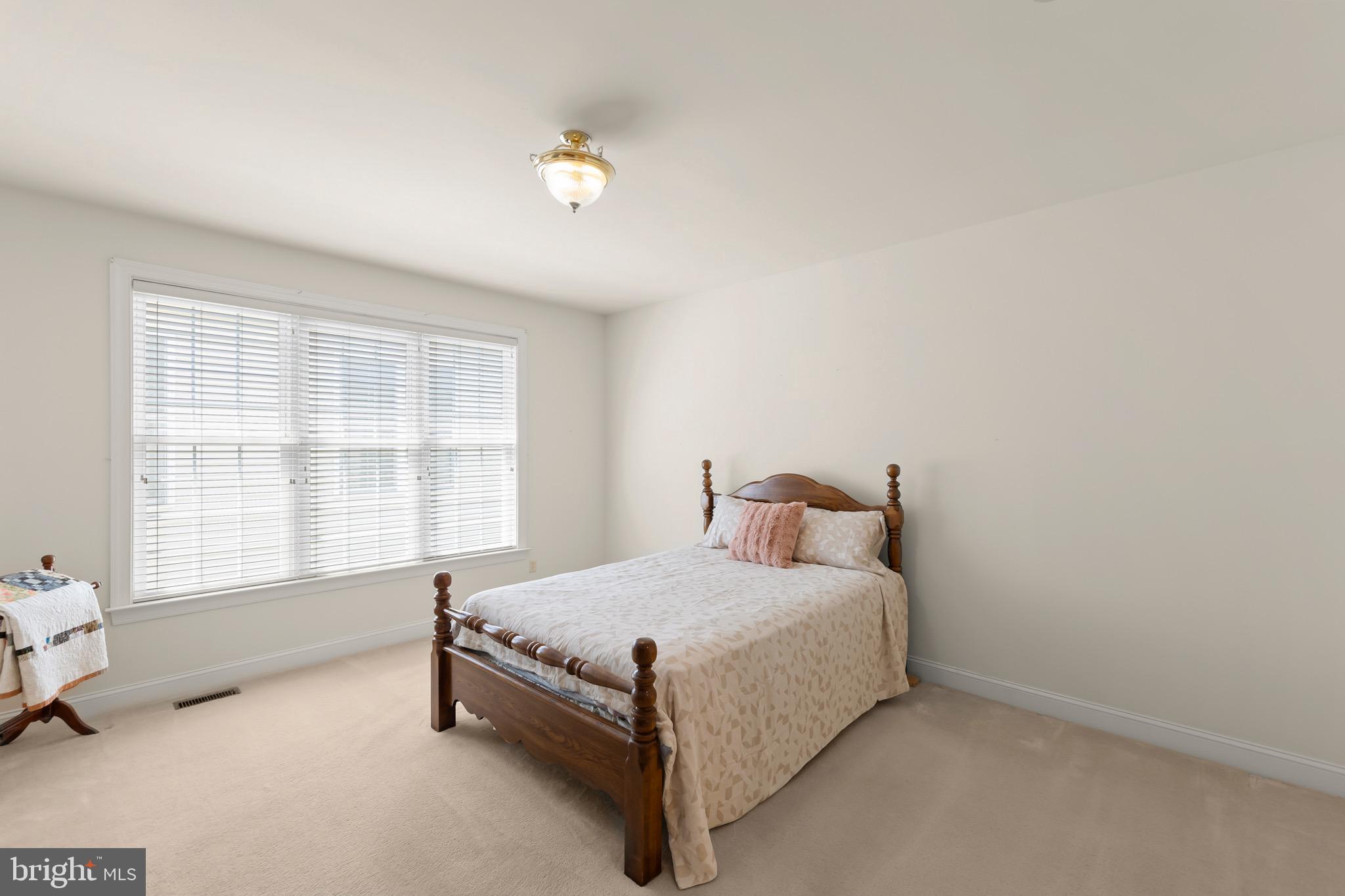 152 Harvest Ridge Drive Winchester, VA 22601 - Photo 17 of 43 a bed sitting in a bedroom next to a window