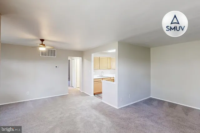 an empty room with a view of a kitchen