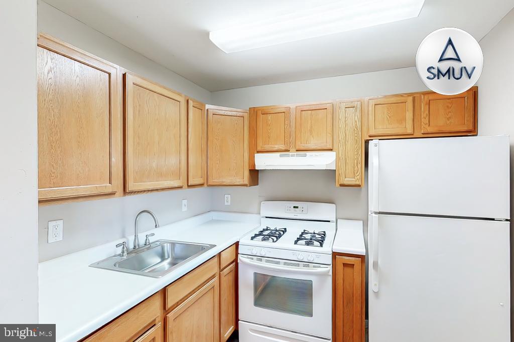 1504 Upshire Road, Unit F2 Baltimore, MD 21218 - Photo 6 of 22 a kitchen with a sink a stove and a refrigerator