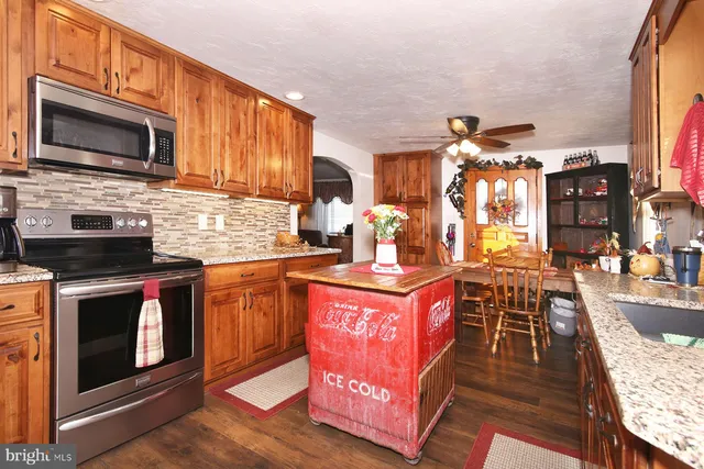 a kitchen with stainless steel appliances granite countertop a stove a sink and a microwave