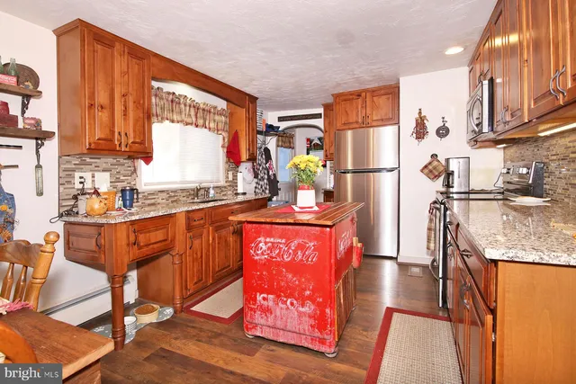 a kitchen with stainless steel appliances granite countertop sink stove and refrigerator