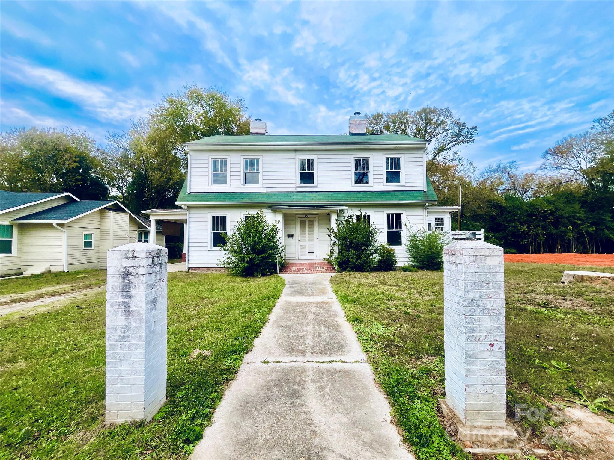 308 Elm Street Lancaster, SC 29720 - Photo 1 of 33 a front view of a house with a yard and potted plants