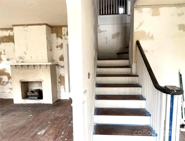 a view of an entryway with wooden floor and a fireplace