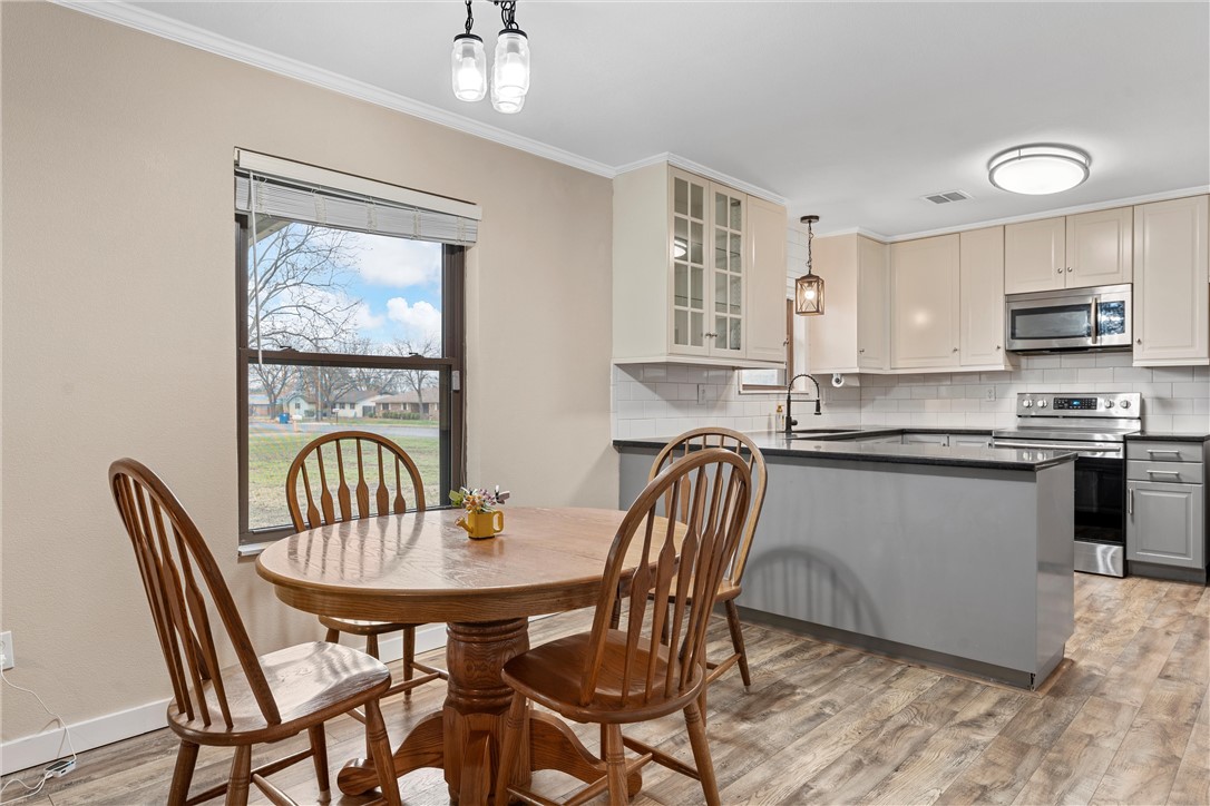 220 Ivy Lane Hewitt, TX 76643 - Photo 11 of 29 a kitchen with stainless steel appliances granite countertop a dining table chairs and a refrigerator