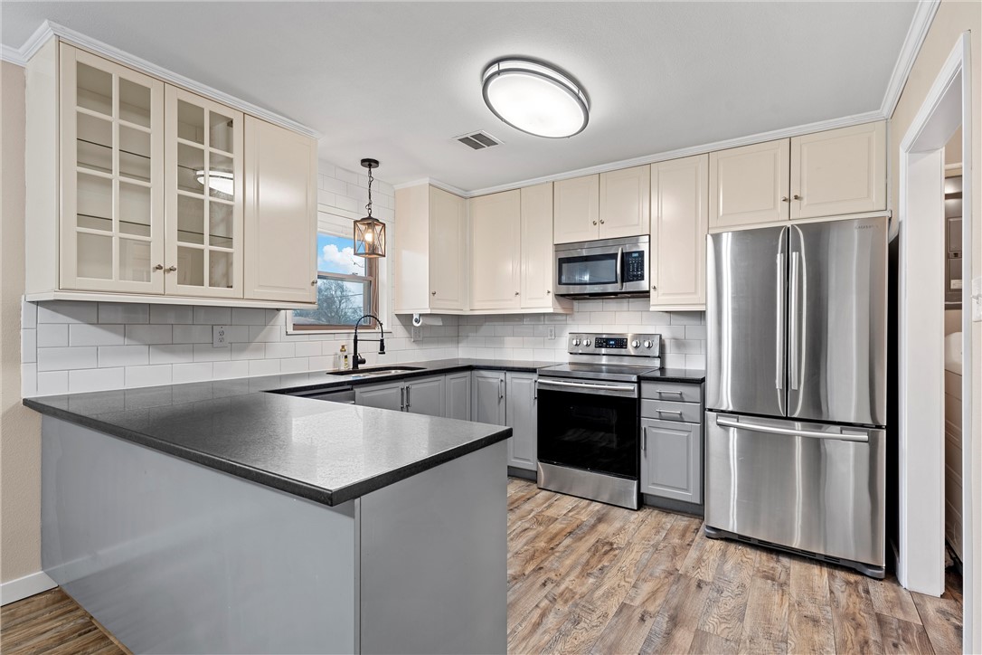 220 Ivy Lane Hewitt, TX 76643 - Photo 5 of 29 a kitchen with kitchen island granite countertop a stove top oven a sink and a refrigerator