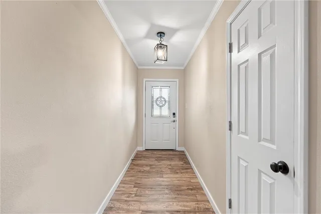 a view of a hallway with wooden floor and entryway