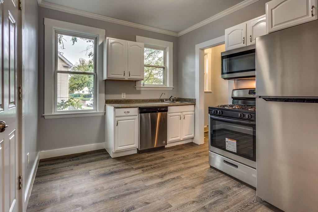 10 Winter Street, Unit 3 Boston, MA 02110 - Photo 4 of 7 a kitchen with a stove a sink and a microwave