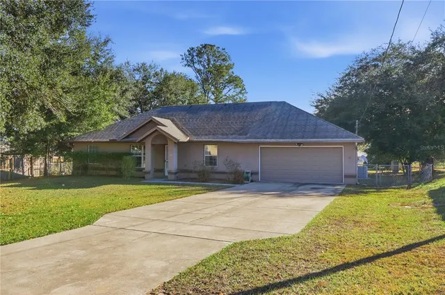 a view of a house with a yard and large tree