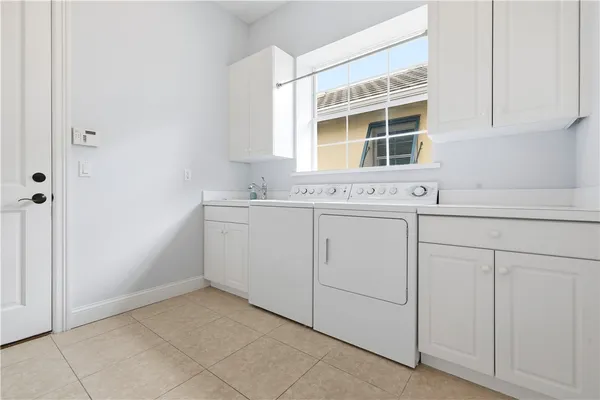 a view of a kitchen with white cabinets washer and dryer