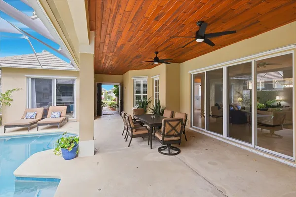 a view of a patio with table and chairs potted plants fire pit and wooden fence