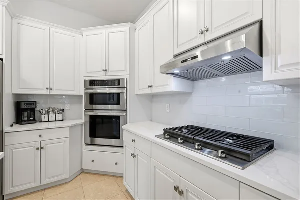 a kitchen with white cabinets and appliances
