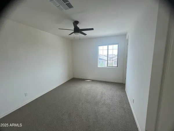 an empty room with a window and a ceiling fan