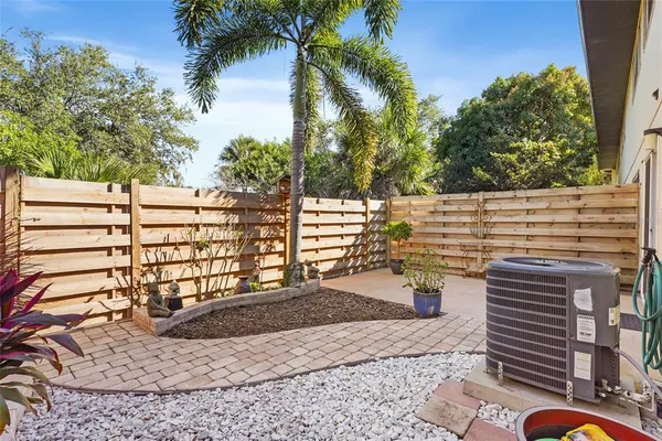 a view of a patio with table and chairs with wooden fence